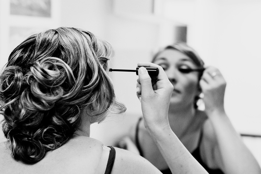 bride putting mascara on in the mirror