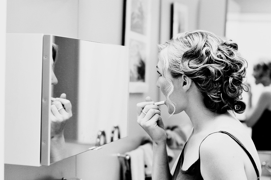 a bride getting ready in the mirror
