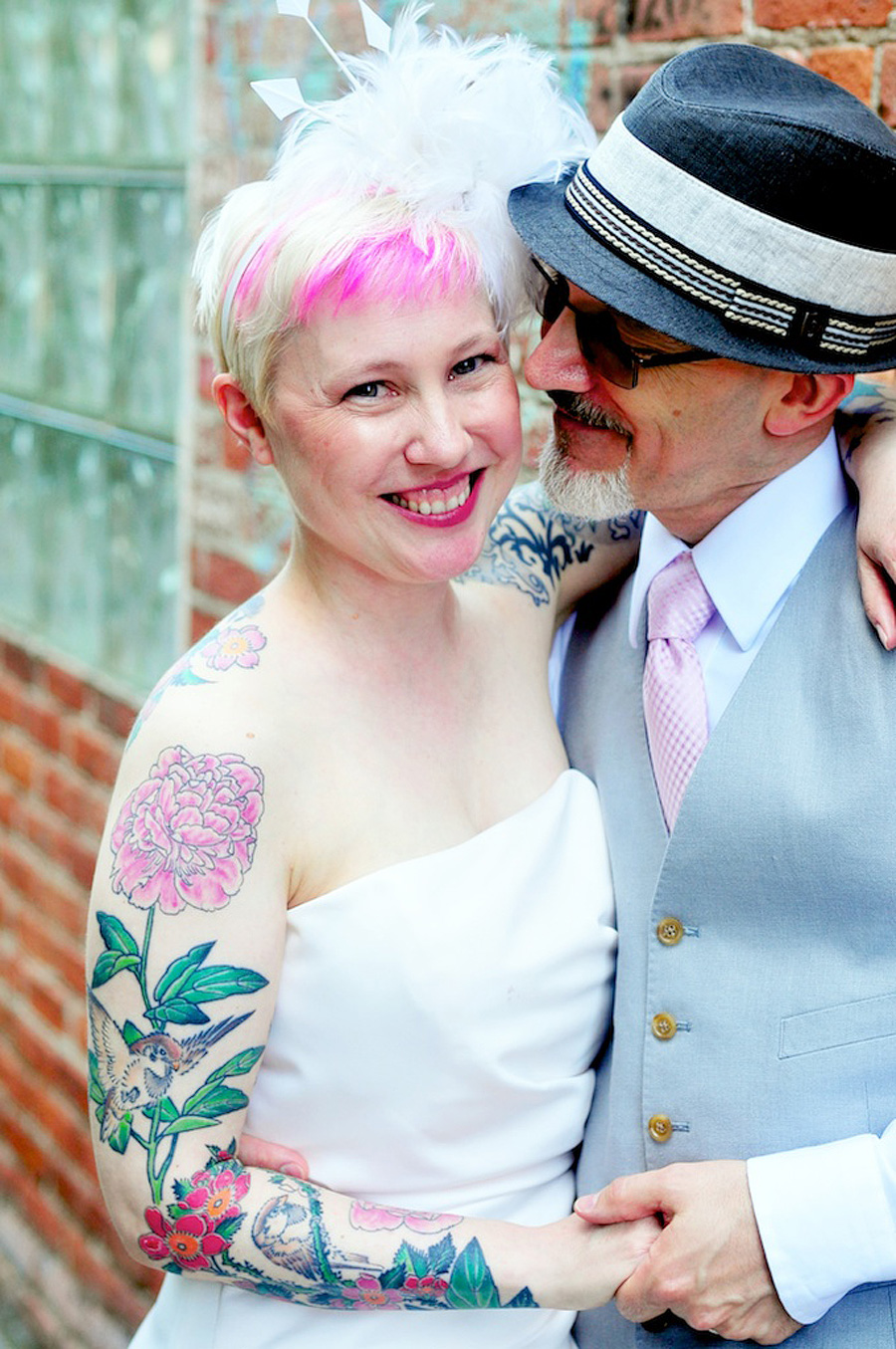 tattooed bride with pink hair and groom in fedora