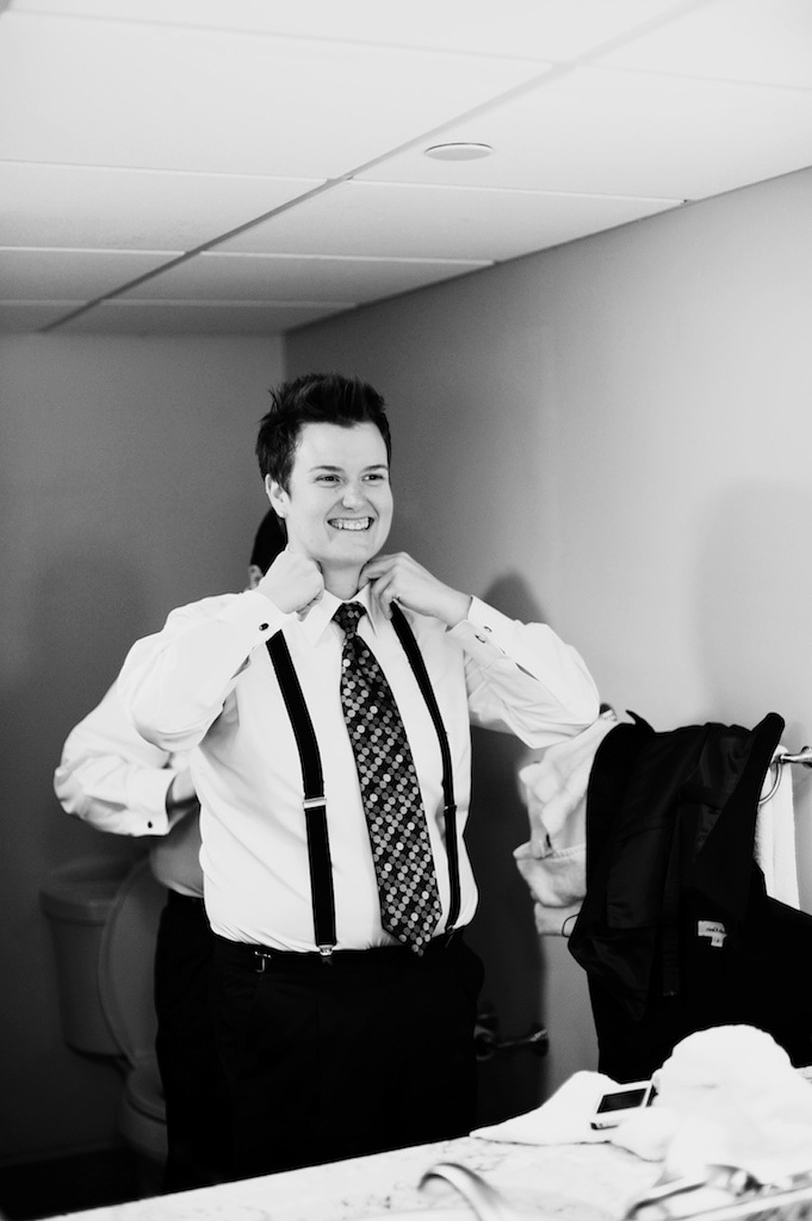 bride in suspenders getting ready