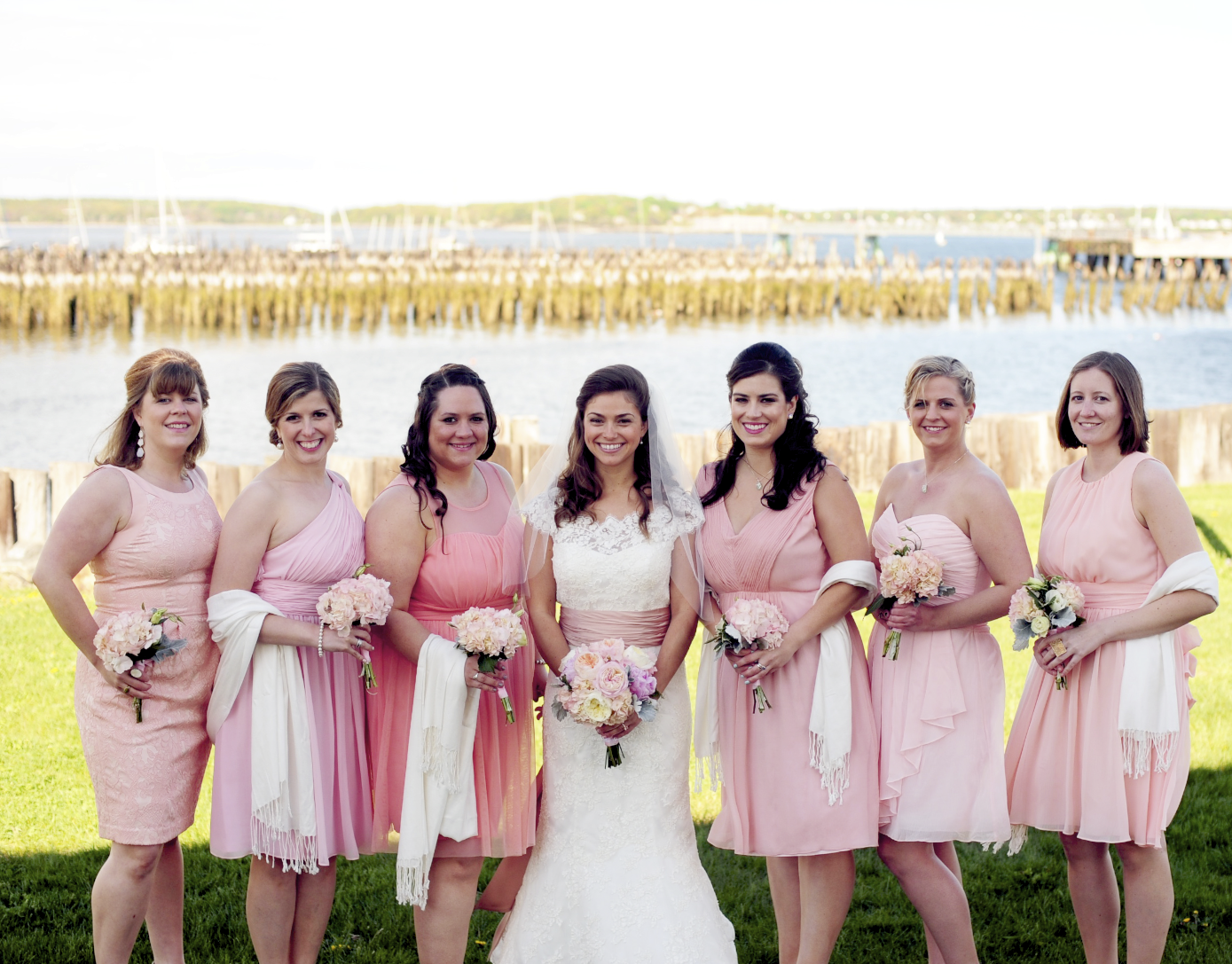 Hillary's bridesmaids wore different shades of pink in different styles, but coordinated with matching white pashminas!