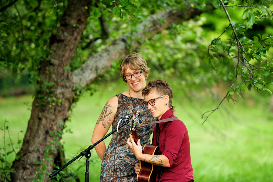 tattooed musicians singing at an outdoor maine wedding