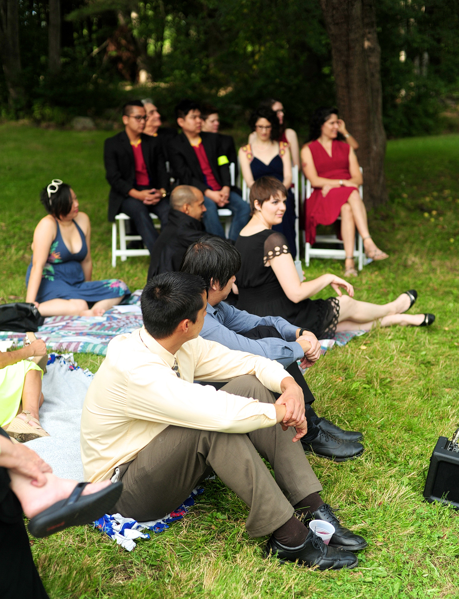 guests sitting in grass on blankets at an outdoor maine wedding