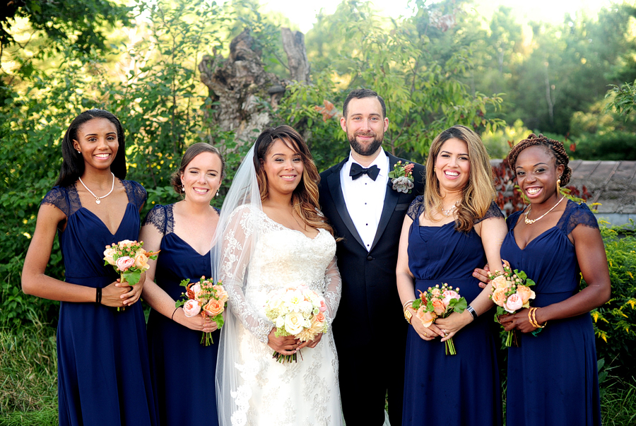 couple with bridesmaids in navy blue dresses
