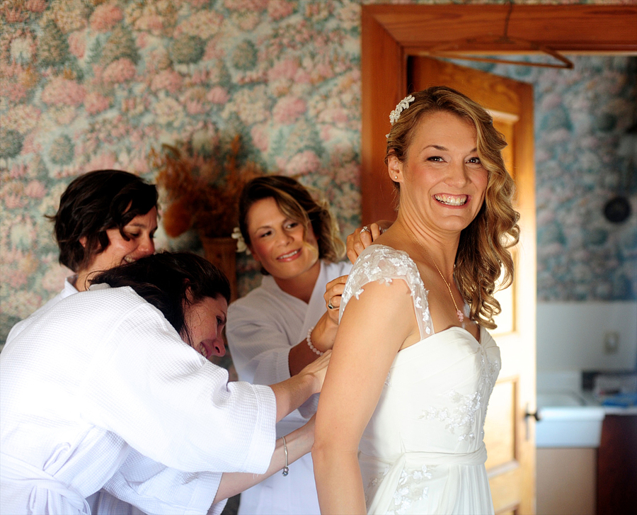 bride getting help into her wedding dress
