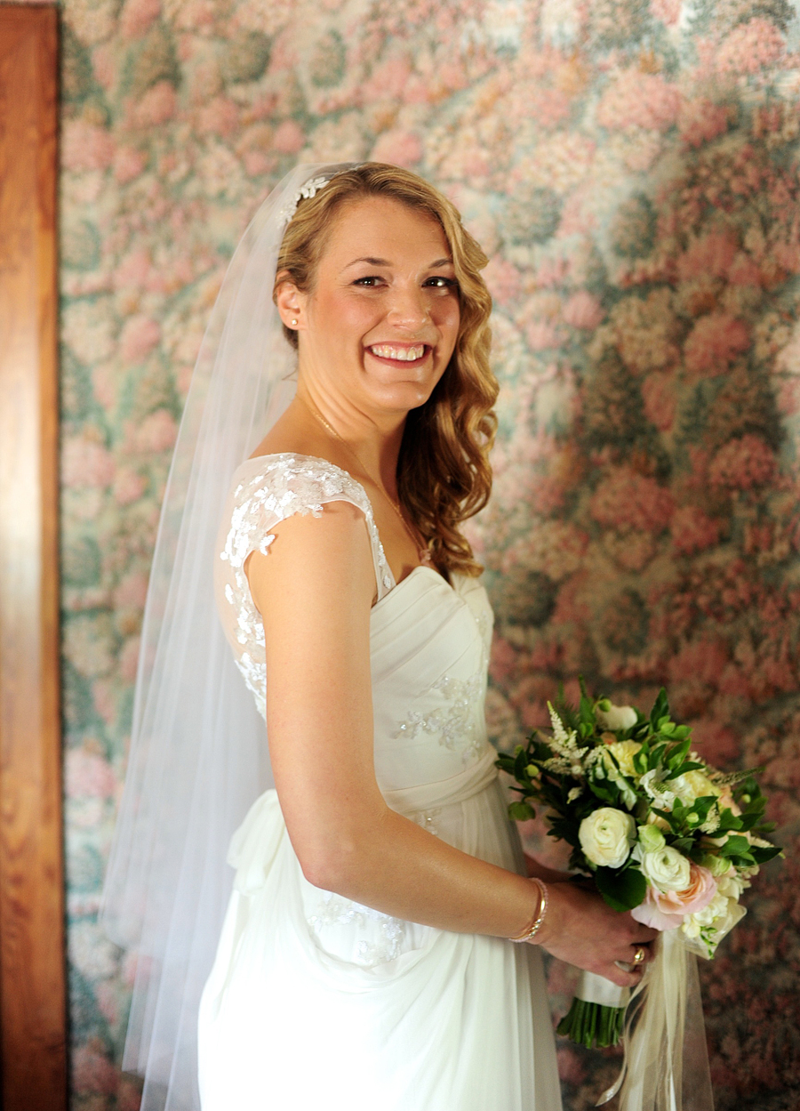bridal portrait with veil in front of floral wallpaper