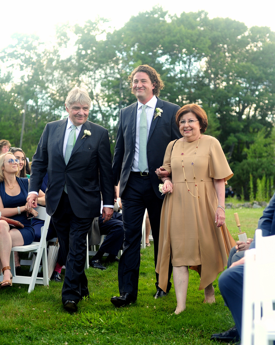 groom walking down the aisle with both parents