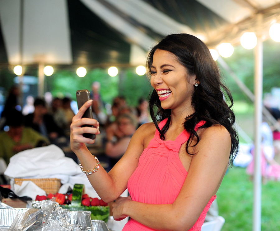 guest laughing and taking a photo at a wedding reception