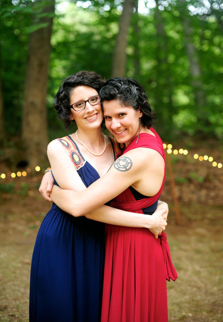 bride in a navy blue dress hugging her sister