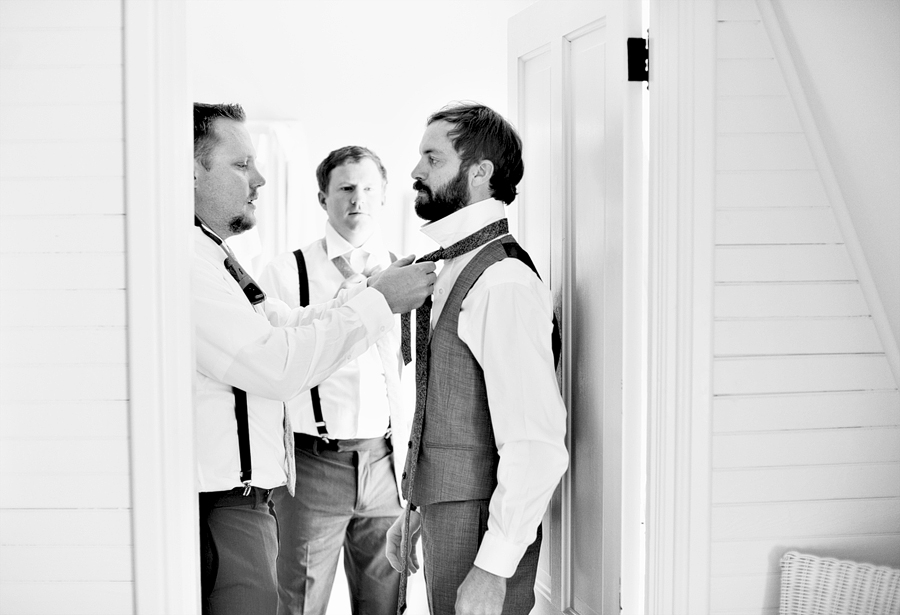 groomsmen helping the groom with his tie