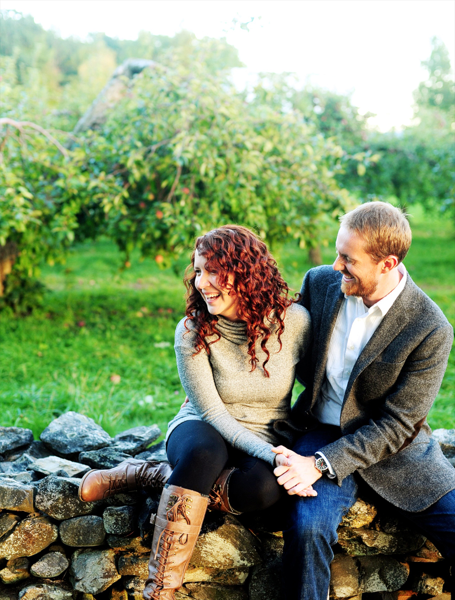 couple laughing on a rock wall in standish, maine