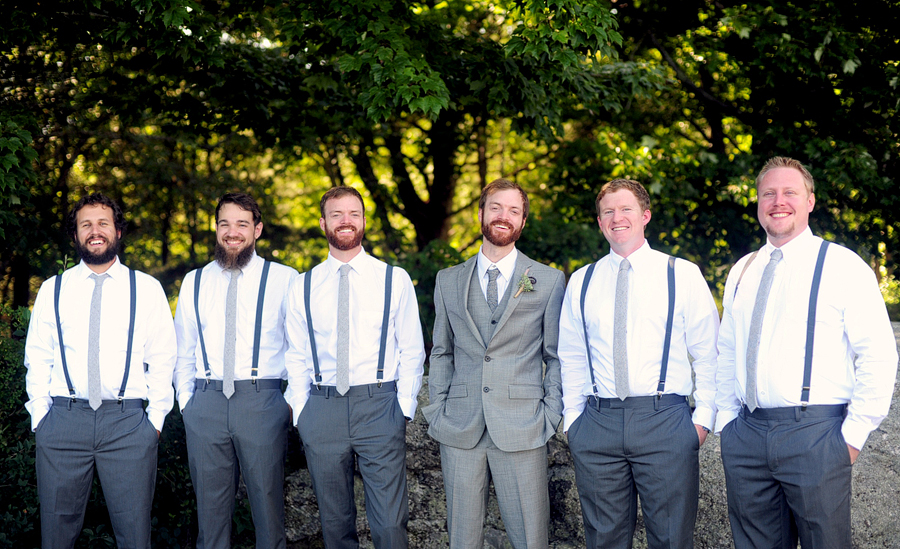 groom posing with his groomsmen in suspenders
