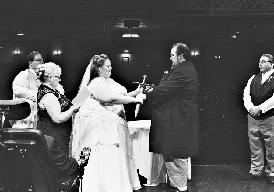 couple exchanging a sword during their vows
