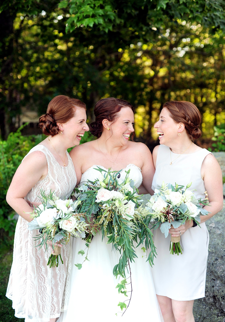 bride laughing with her twin sisters