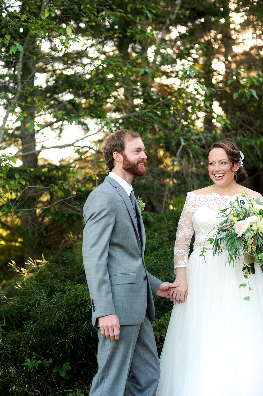 a couple laughing in the woods on their wedding day