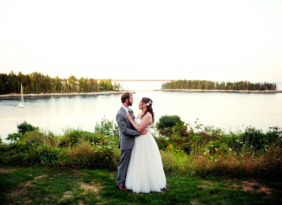 couple standing on the maine coast at sunset