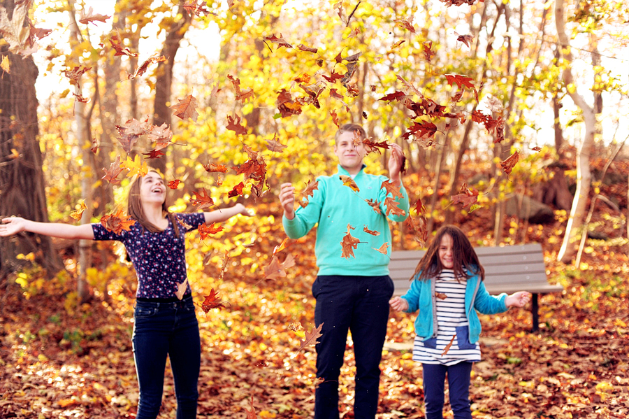 siblings throwing leaves in the air