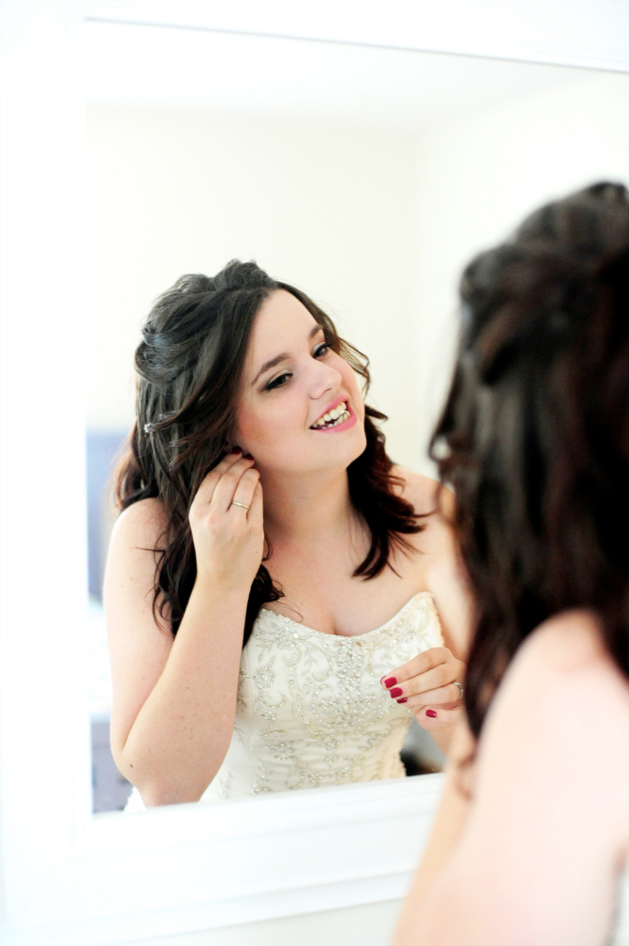 bride getting ready in the mirror
