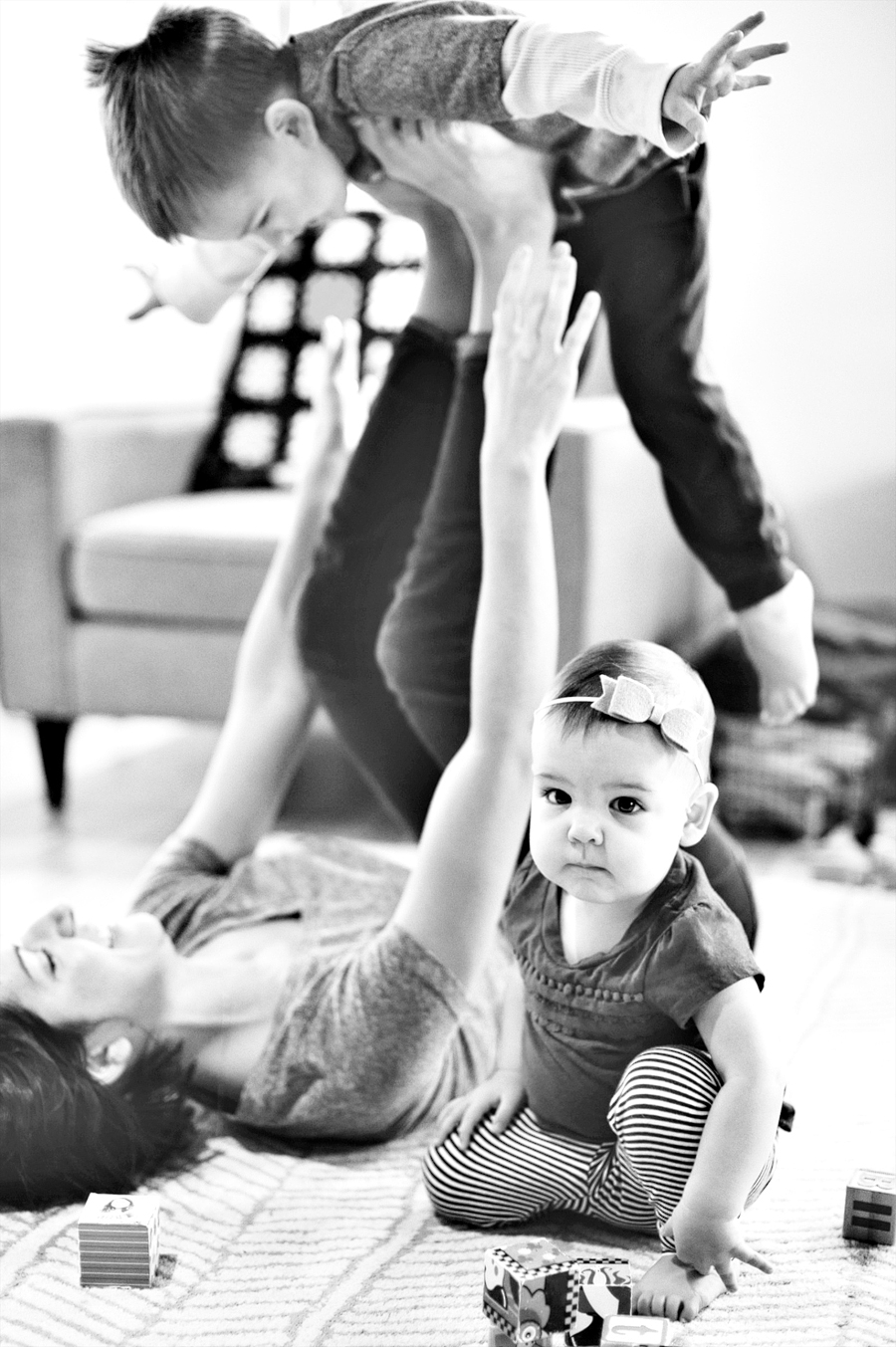 little boy playing airplane with mom