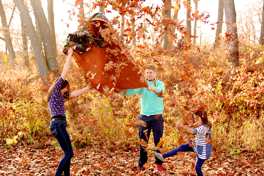 siblings throwing fall leaves in the air