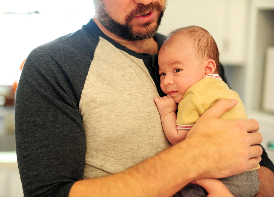 bearded man holding baby to chest