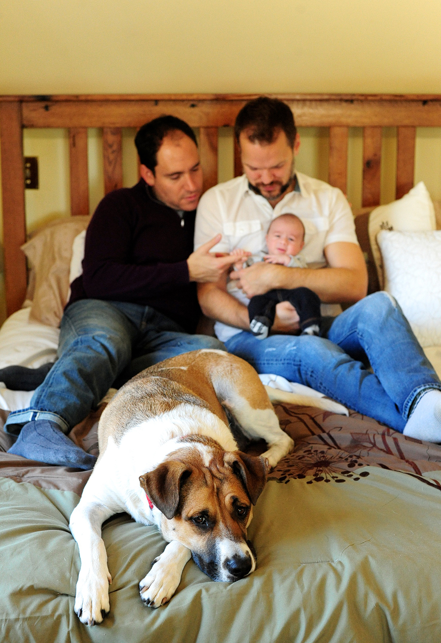 couple on bed with baby and dog