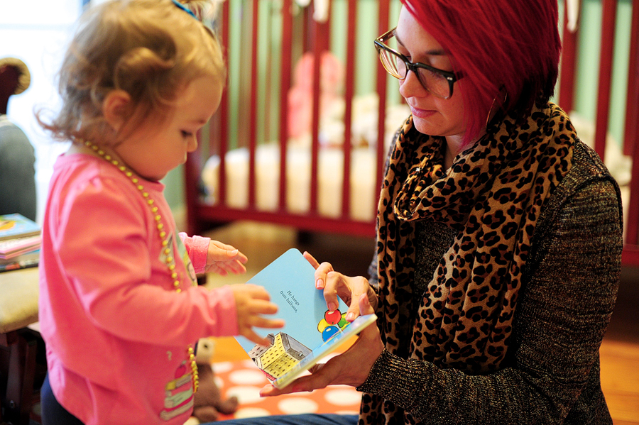 mother in glasses reading to her daughter