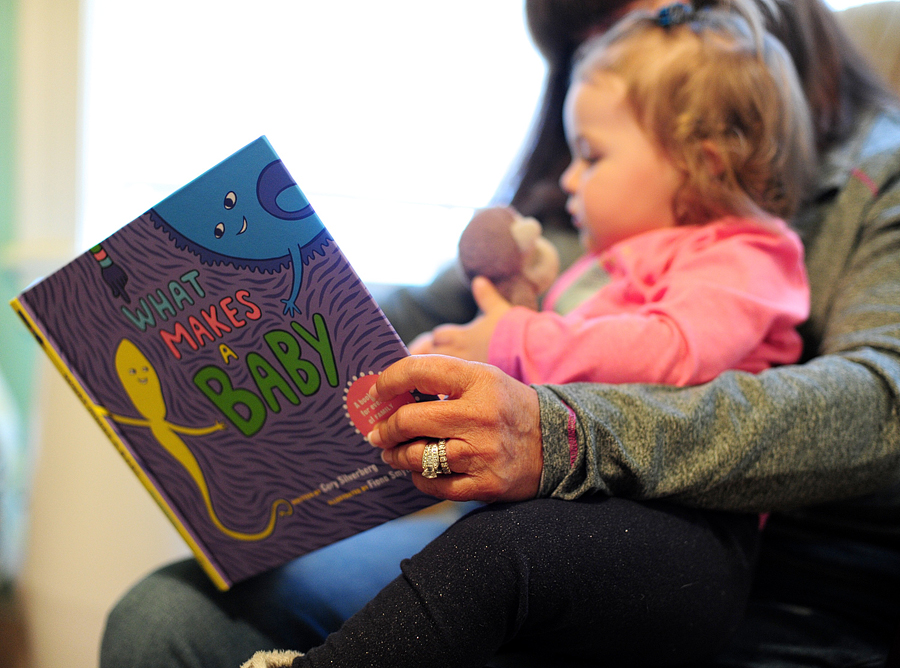 little girl reading what makes a baby