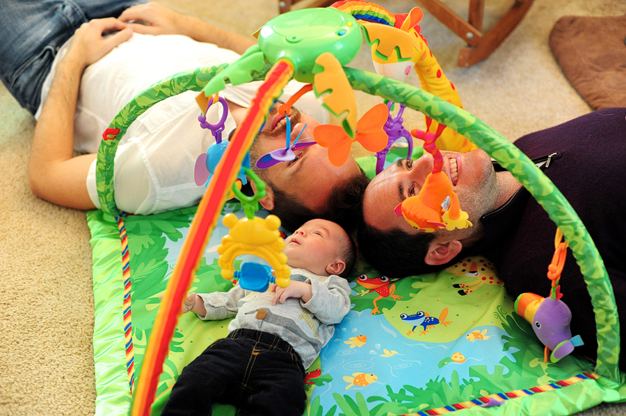 dads and baby laying on floor