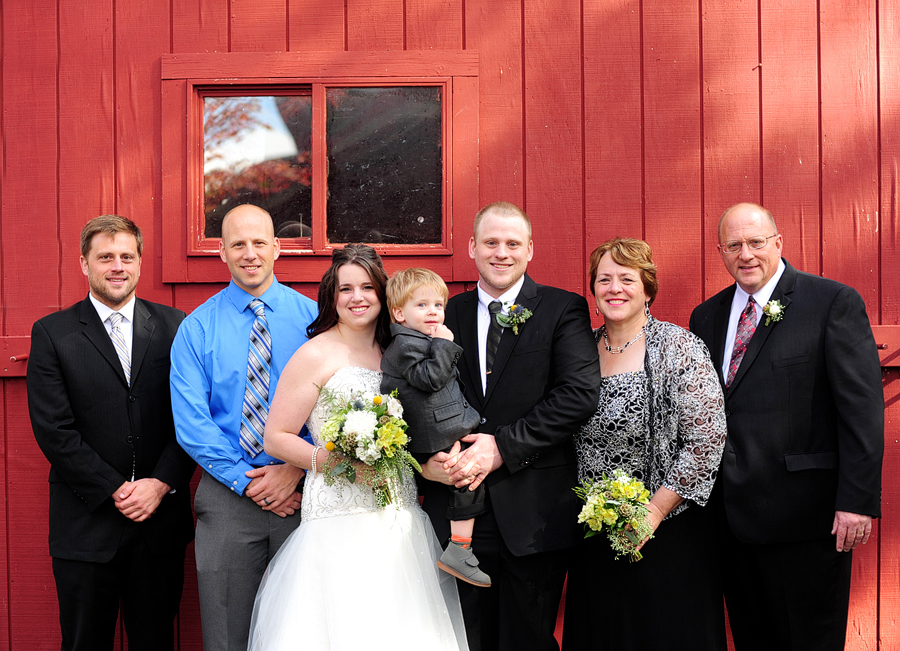 family photo against a red barn
