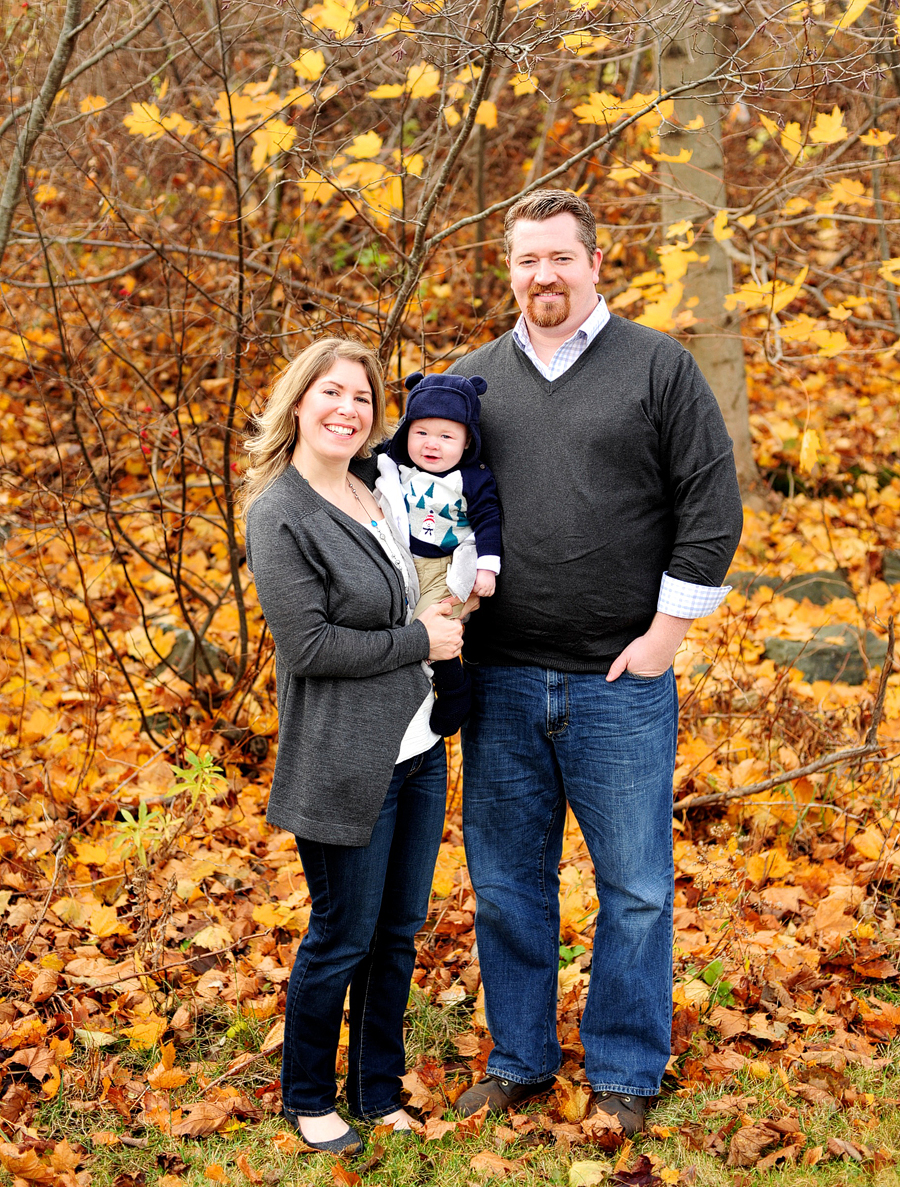 family with baby posing outside