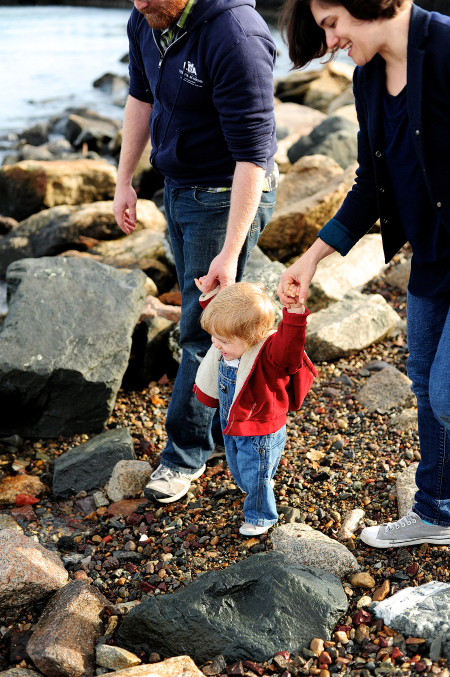 family walking on rocky beach on castle island