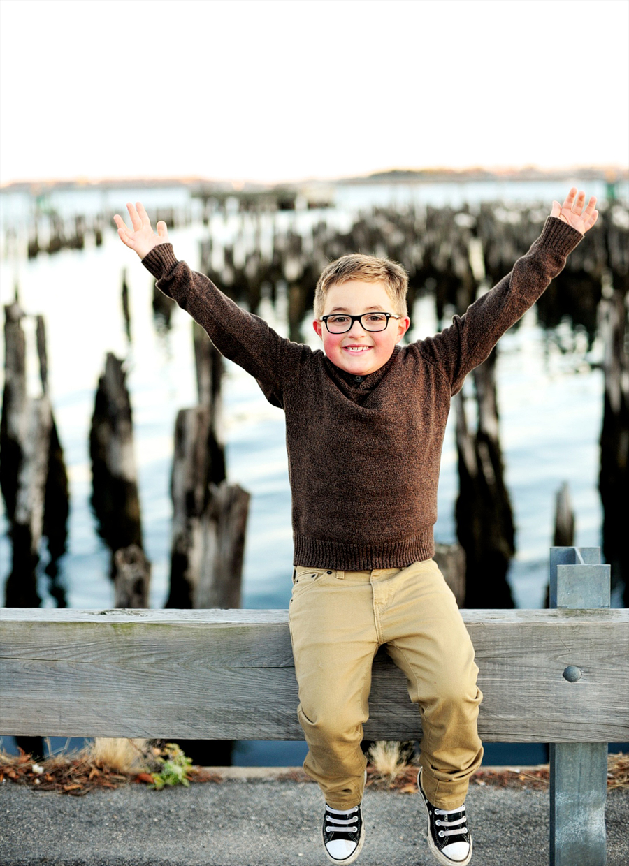 kid in glasses by the ocean in portland, maine