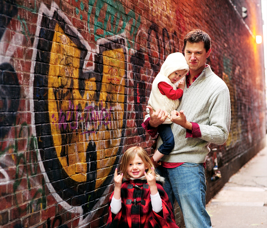 father and daughters in front of graffiti