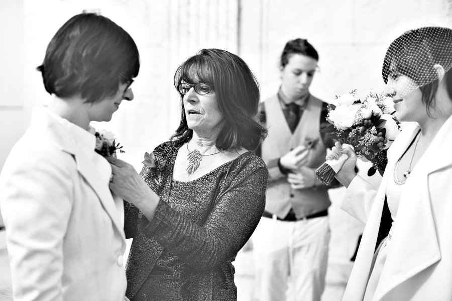 mom helping bride with boutonniere