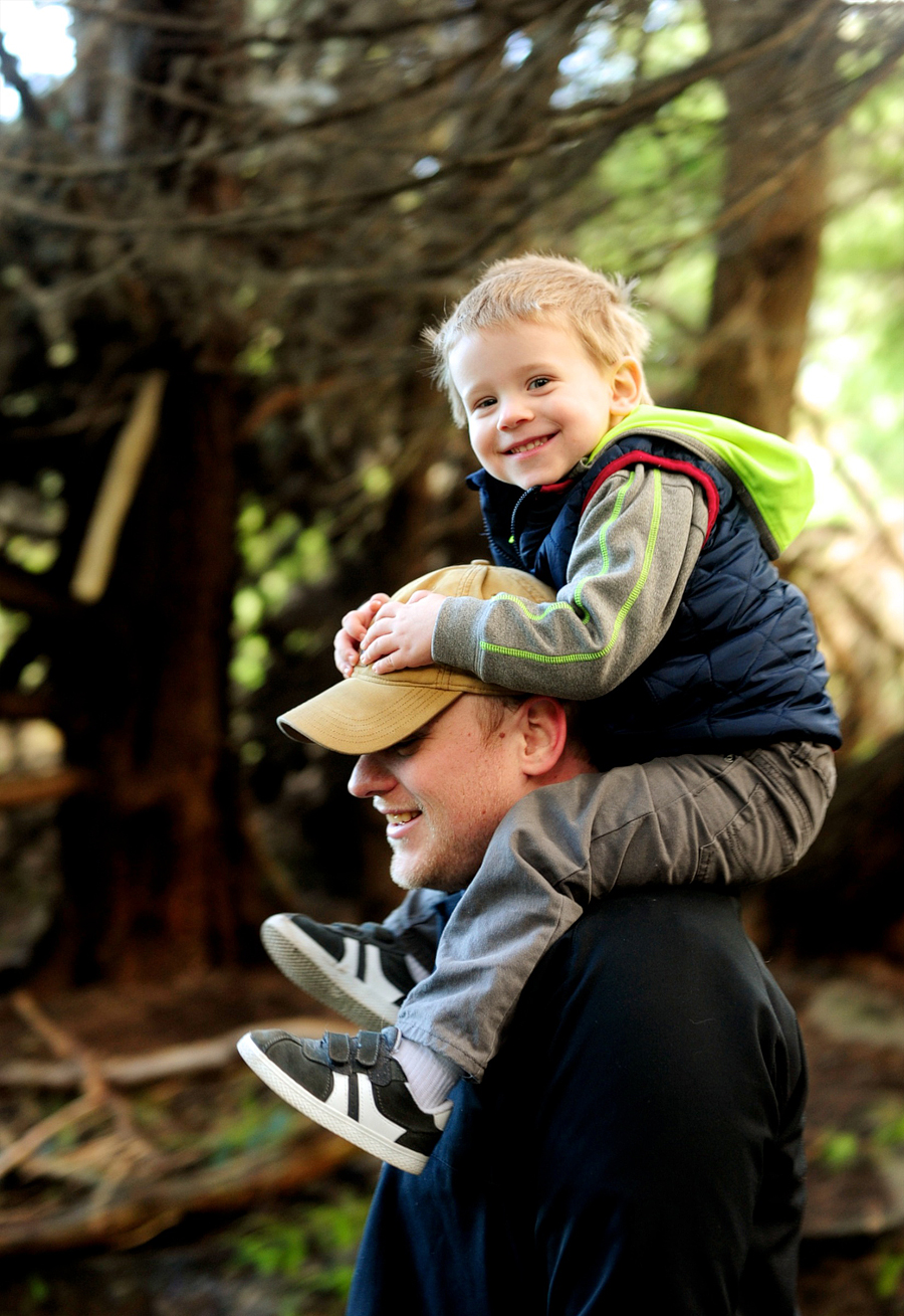 son riding on dad's shoulders