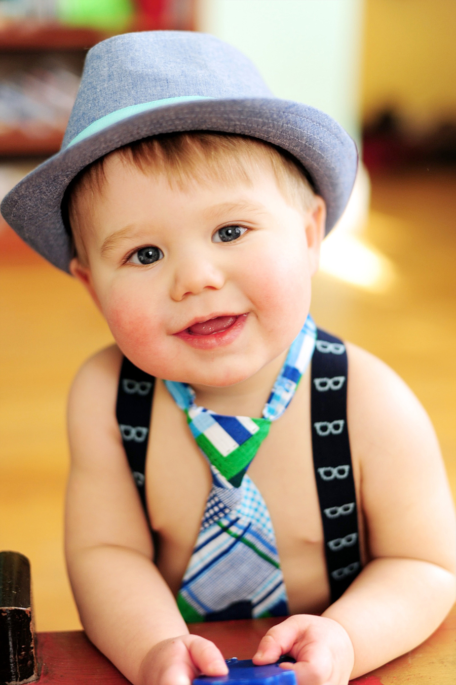 smiling baby in hat and tie