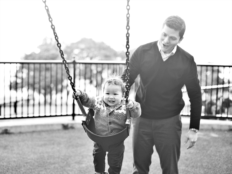 dad pushing son on swing