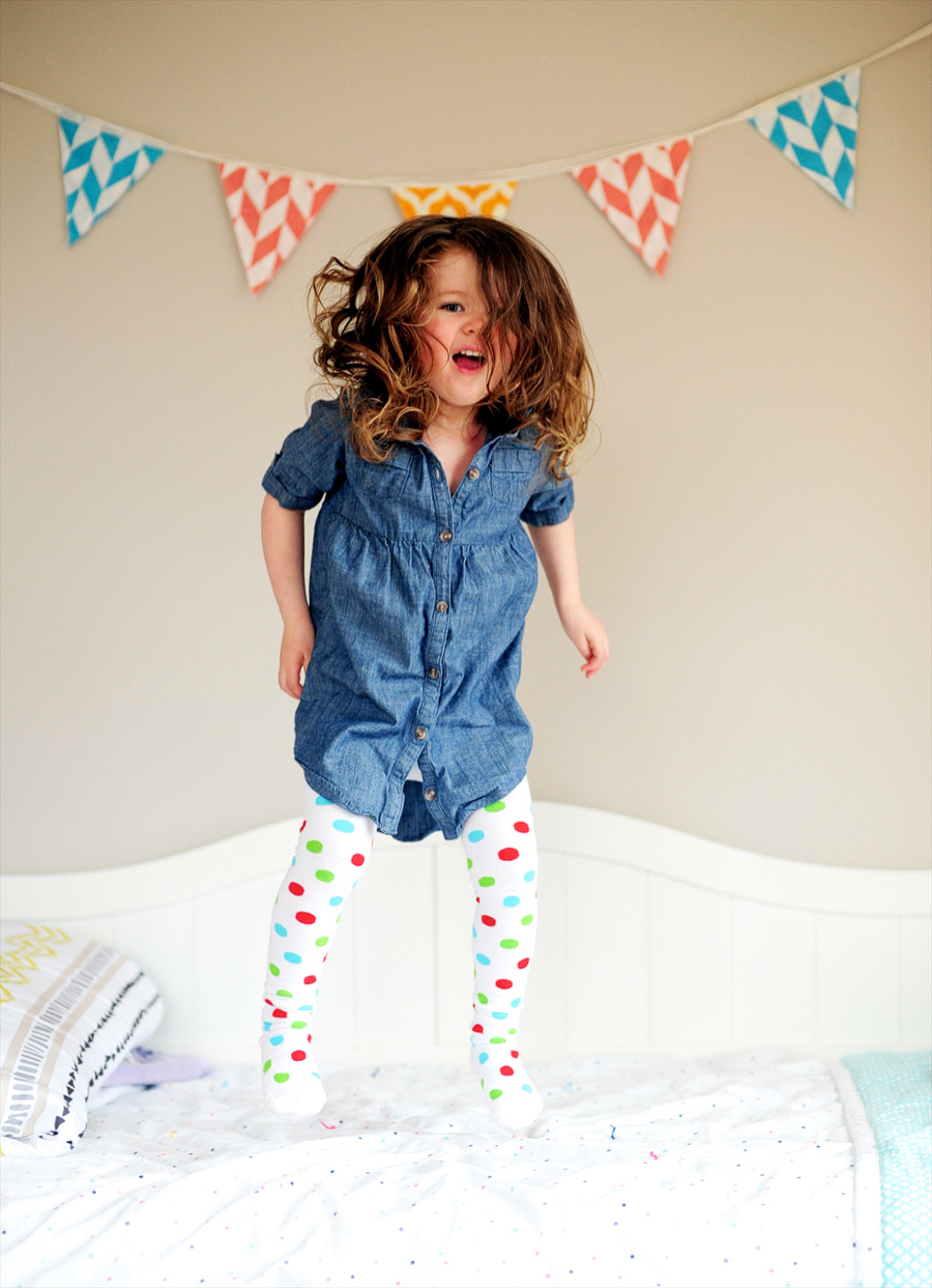 girl jumping on her bed