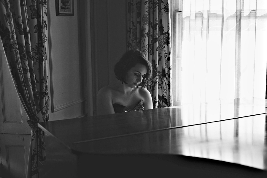 black and white photo of woman playing piano