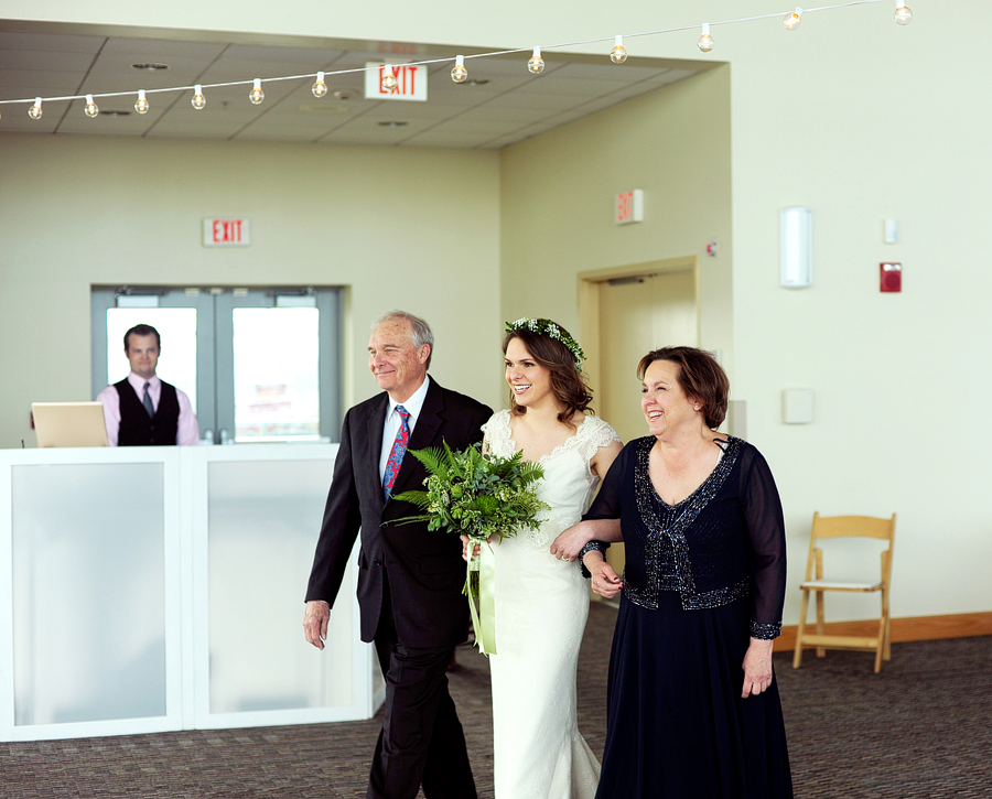 bride walking down the aisle with parents