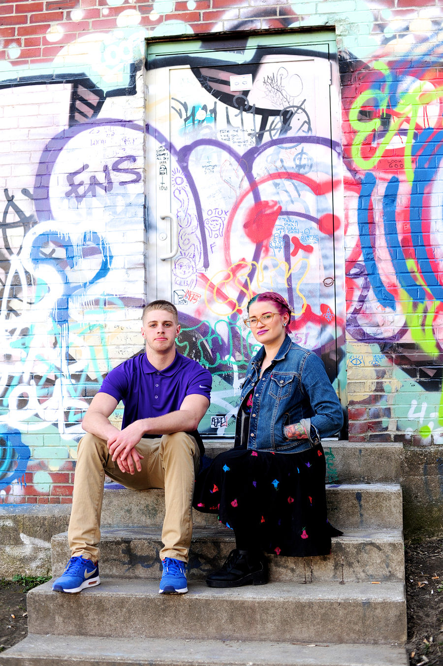 brother and sister in front of graffiti