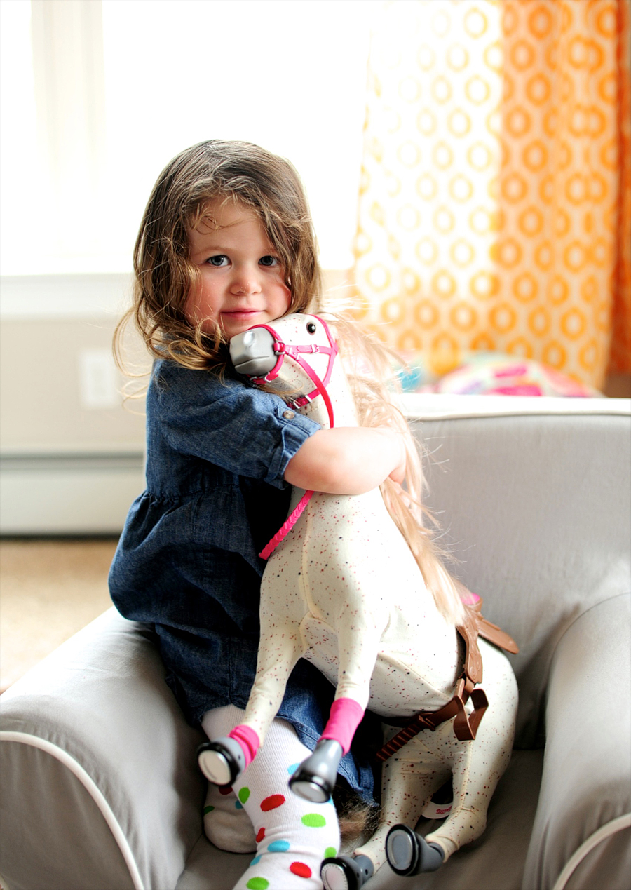 girl hugging her toy horse