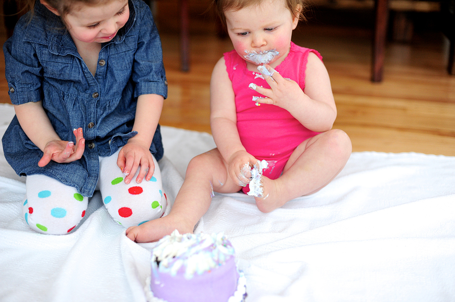 baby with cake on her foot