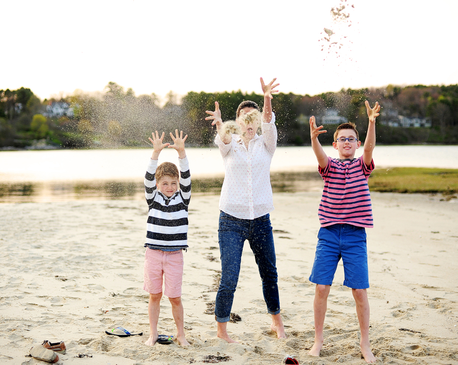 family throwing sand on the beach