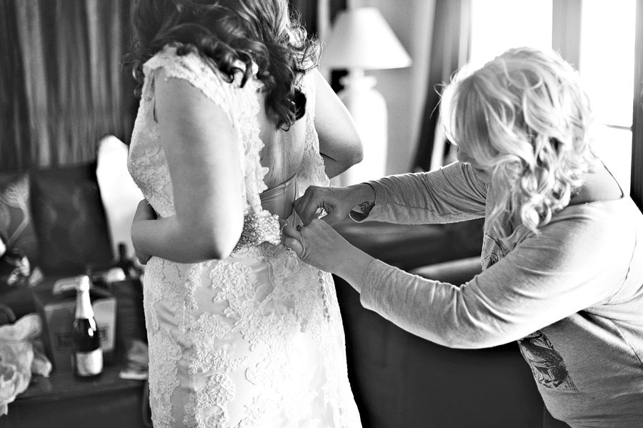 bridesmaid helping the bride with her dress