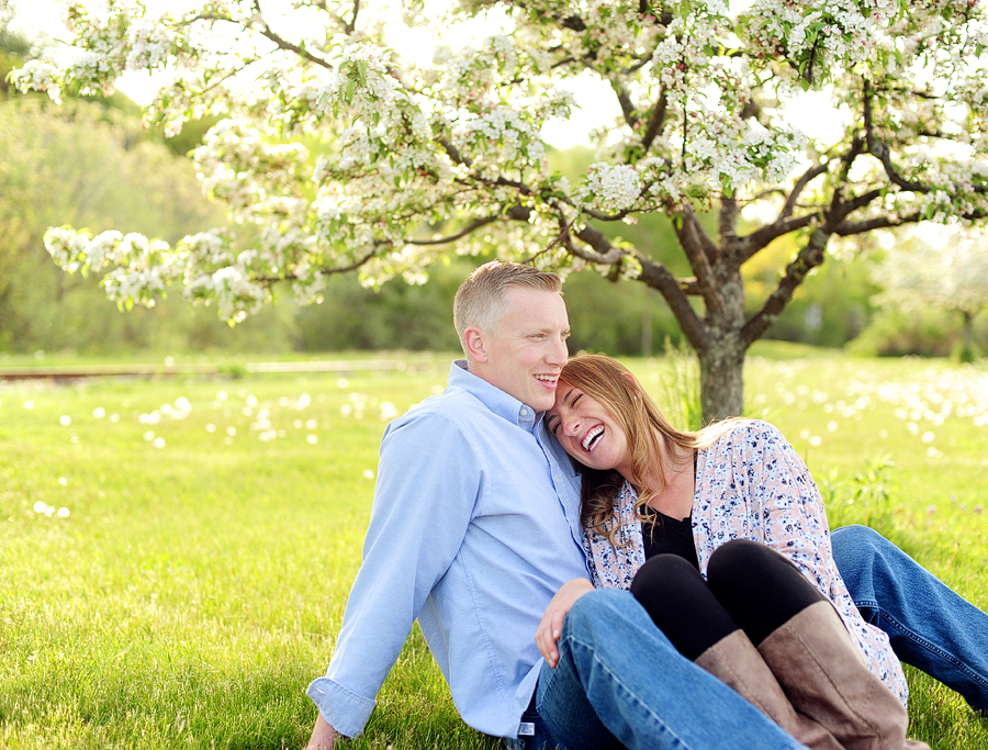 couple cuddling under blooming tree