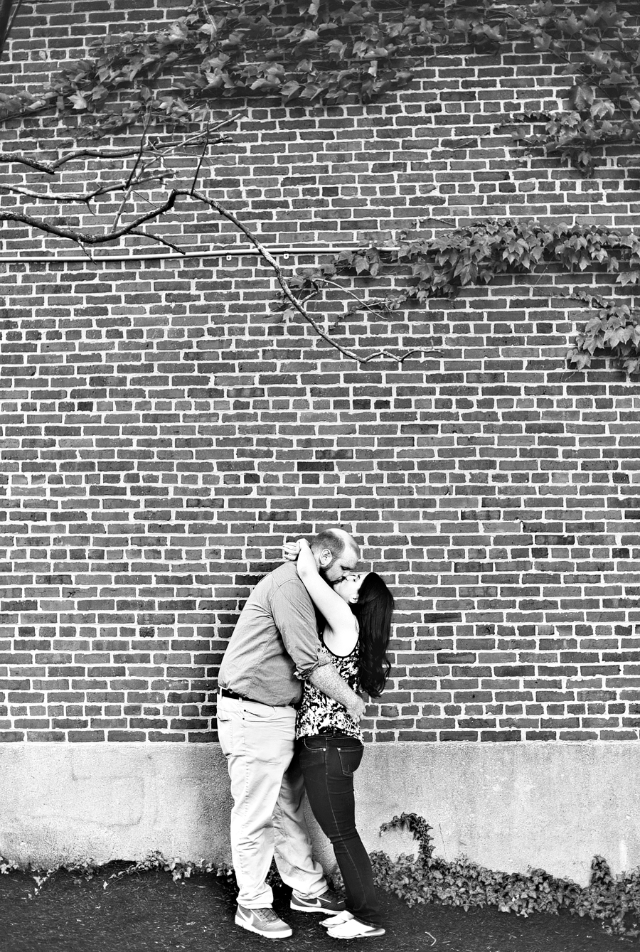 black and white engagement photo with brick and ivy