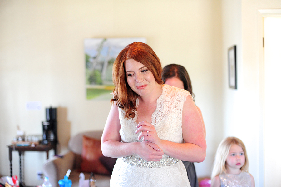 redhead bride getting ready in a lace dress