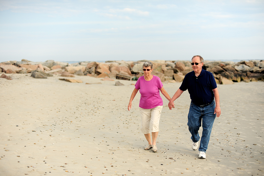 couple walking hand-in-hand at the beach